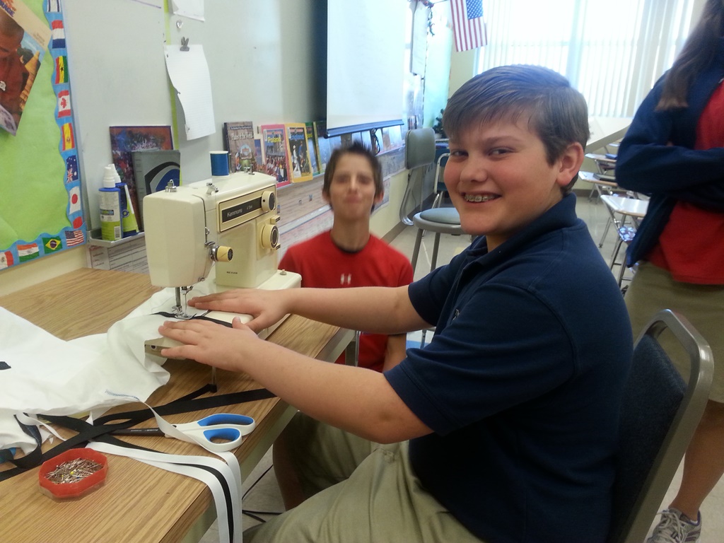 Daniel Kamp taking a turn at the sewing machine